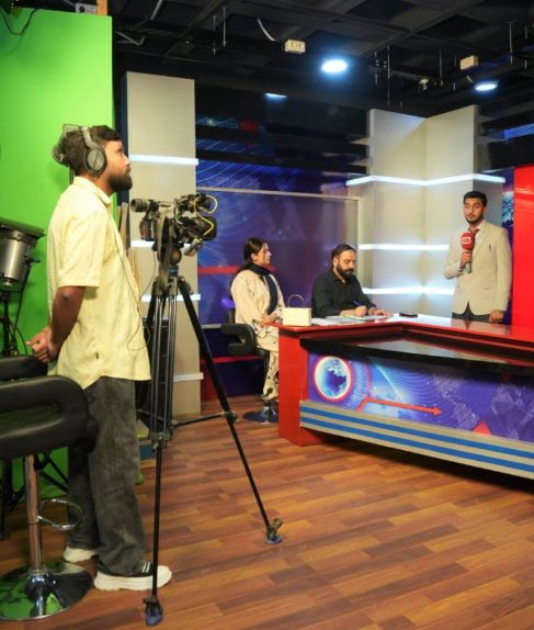 Fellows in a Dunya News studio with a camera operator and presenter